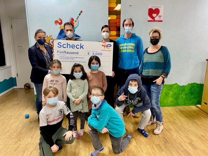 Gruppenfoto mit Kindern und Vertreterinnen und Vertretern der Stiftung Agapedia bei der symbolischen Übergabe eines Spendenschecks über 5.000 Euro von TotalEnergies. Die Spende unterstützt die Projekte der Stiftung zur Förderung und Begleitung von Kindern und Jugendlichen.