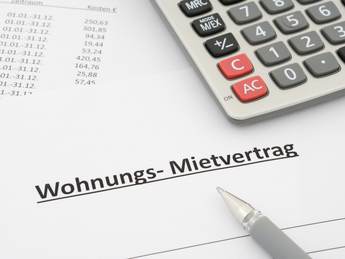 Ein Taschenrechner und ein Mietvertrag liegen vor.