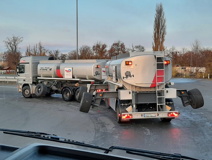Tankwagen mit Anhänger und Stützrädern in der Kurve 