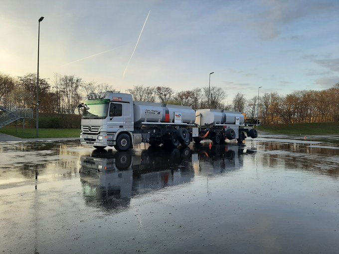 Trankwagen mit Anhänger und Stützrädern auf nasser Fahrbahn